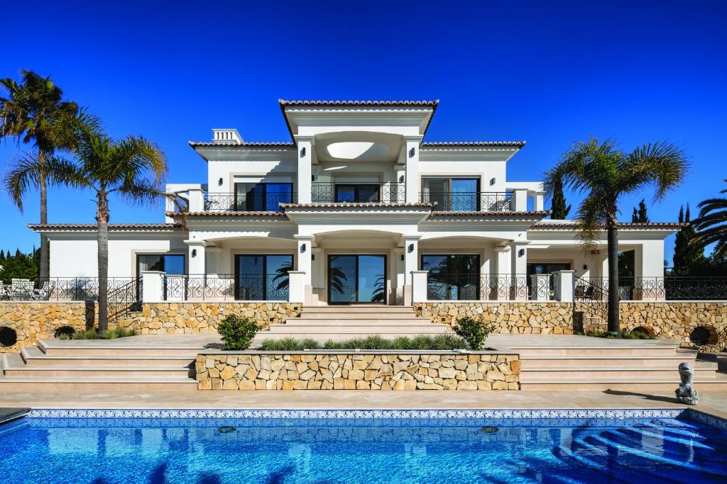 a house with a swimming pool in front of it at Casa Ceu Branco in Carvoeiro