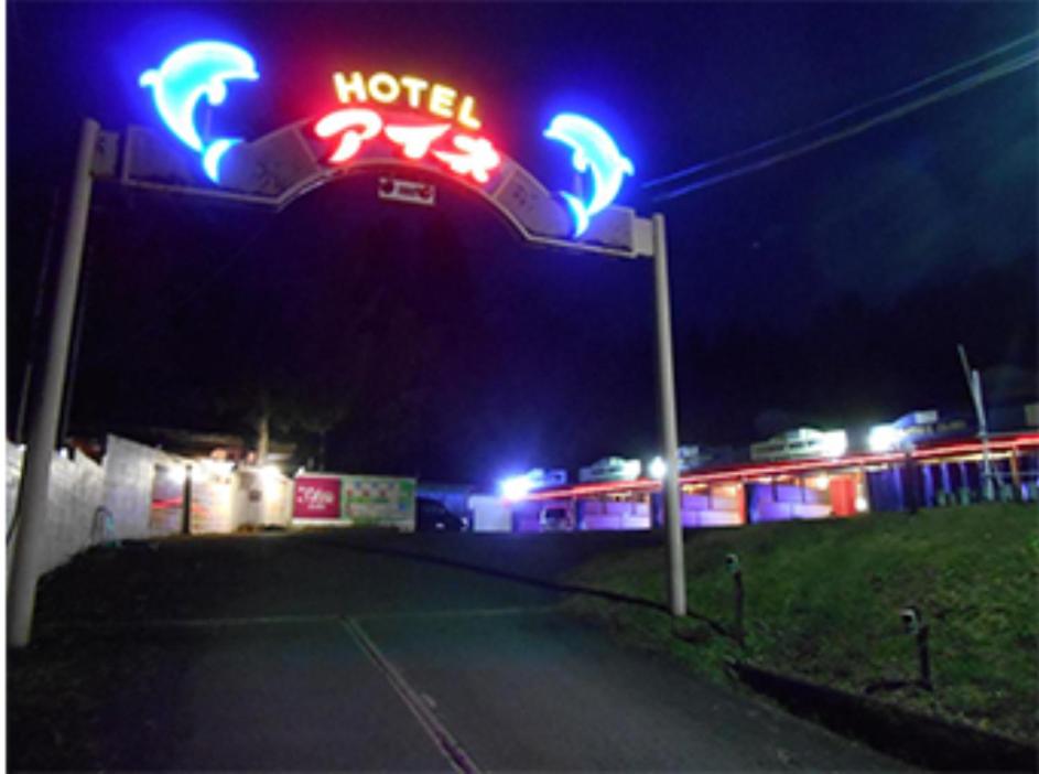 ein Motelschild vor einer Tankstelle nachts in der Unterkunft 綾部アイネ in Ayabe