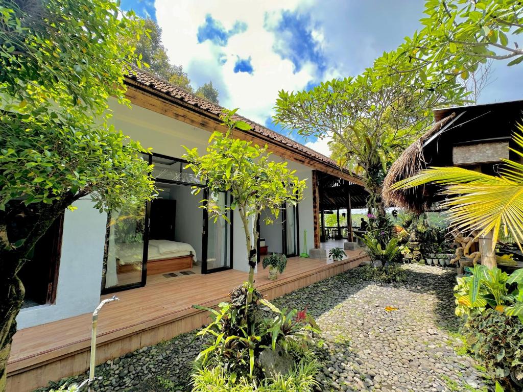 un hostal con terraza y dormitorio en Nang Taro Home Stay, en Penginyahan
