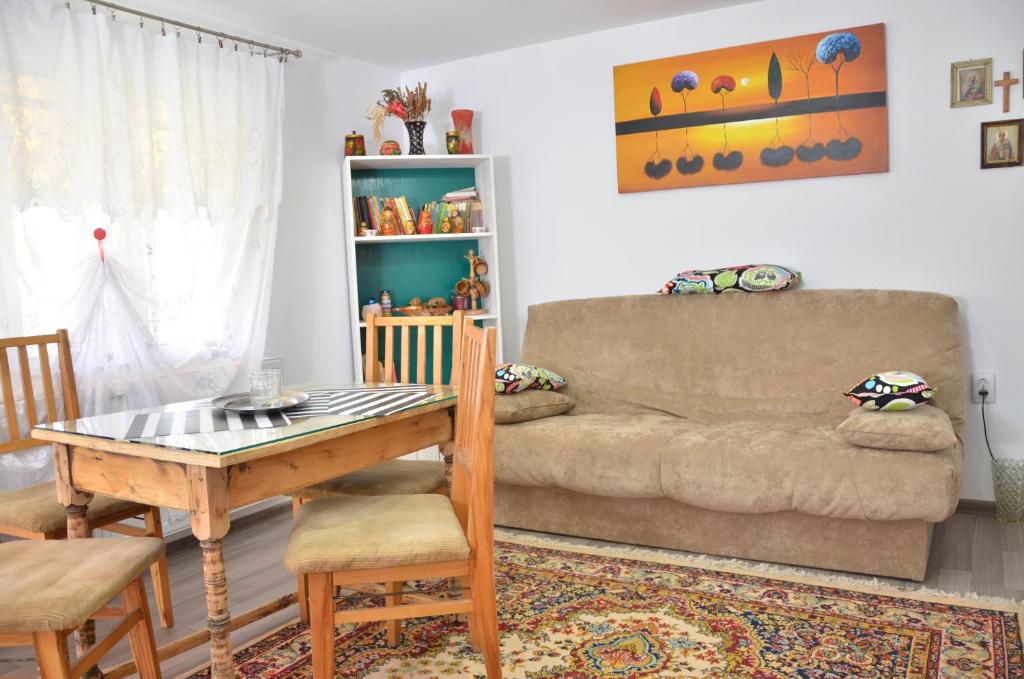 uma sala de estar com um sofá e uma mesa em Casa Marica em Ceahlău