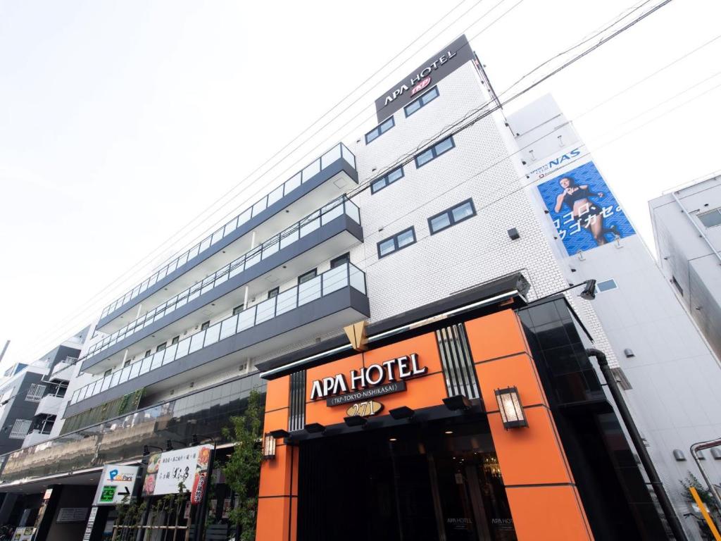 een gebouw met een hotelbord ervoor bij APA Hotel TKP Tokyo Nishi-Kasai in Tokyo