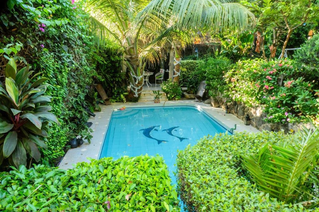 a swimming pool with dolphins in a garden at Fabuleuse Villa Keur Bibou in Dakar