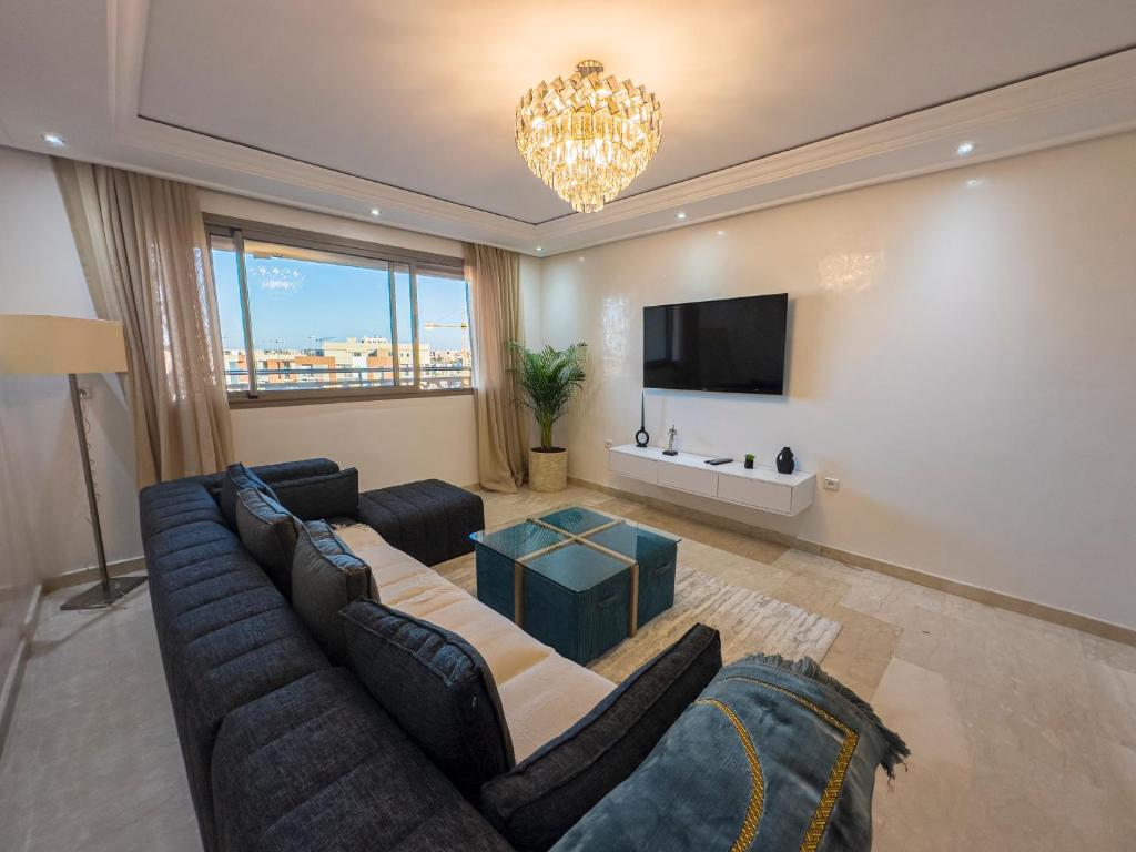 un soggiorno con divano e TV di TheCasaEdition - Gueliz apartment a Marrakech