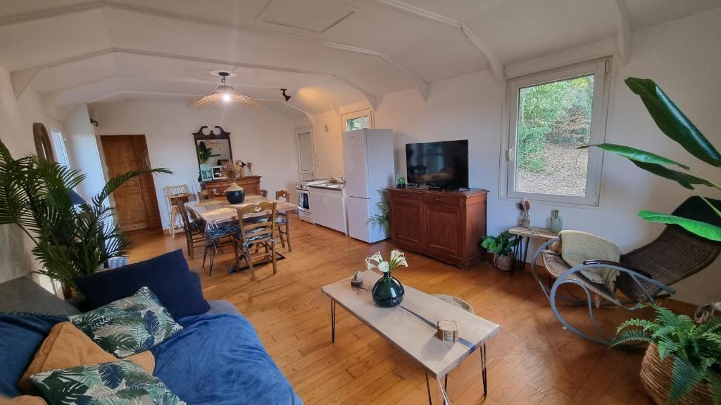 a living room with a couch and a table at L'orée du bois in Hennebont