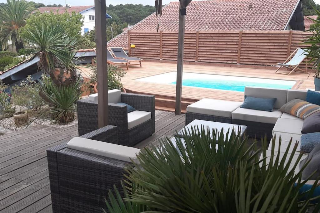 d'une terrasse avec canapés et d'une piscine dans l'arrière-cour. dans l'établissement Villa les Roses, à Capbreton