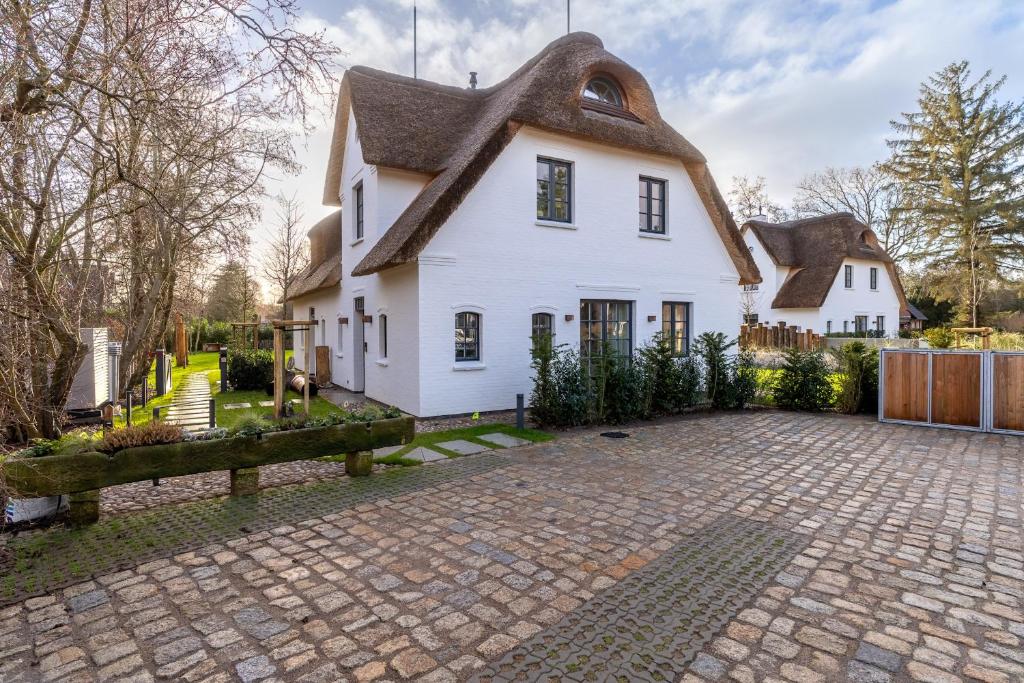 a white house with a thatched roof at weivz SPO Reetdachhaus weivz SPO in Sankt Peter-Ording