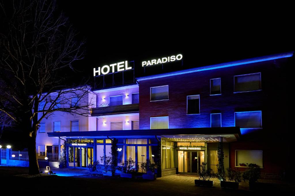 a hotel with a sign on the side of it at night at HOTEL PARADISO in Altedo