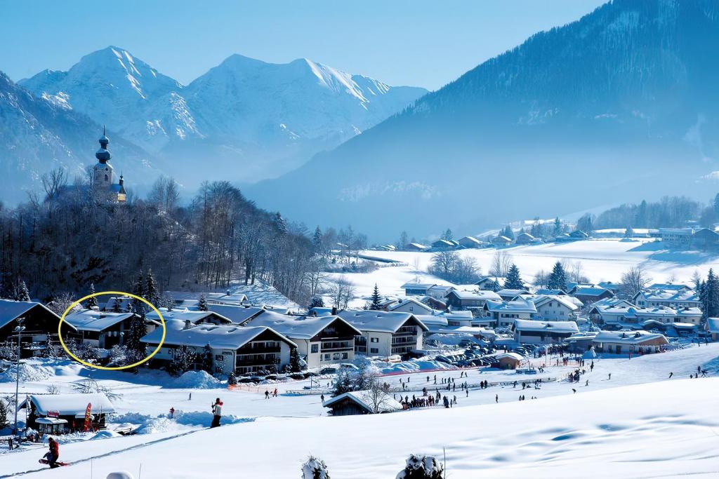 a town covered in snow with mountains in the background at Ferienwohnungen Helga Mayer inkl. Chiemgaukarte in Ruhpolding
