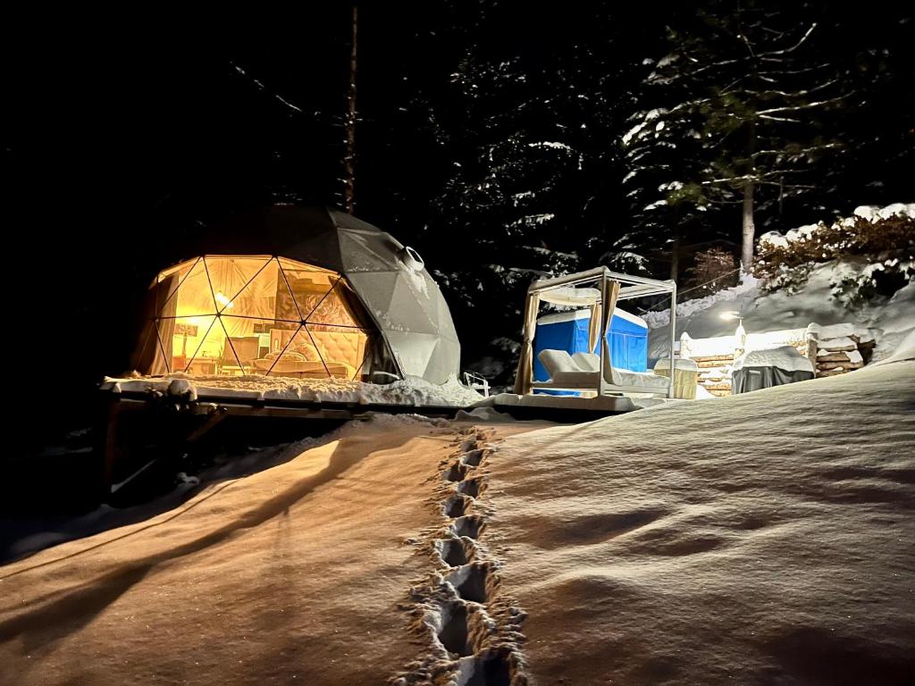 two domed tents in the snow at night at Glamping Špindl in Špindlerův Mlýn