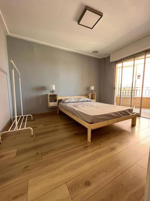 una camera con un letto in una stanza con pavimenti in legno di La morada de Crevillent a Crevillent