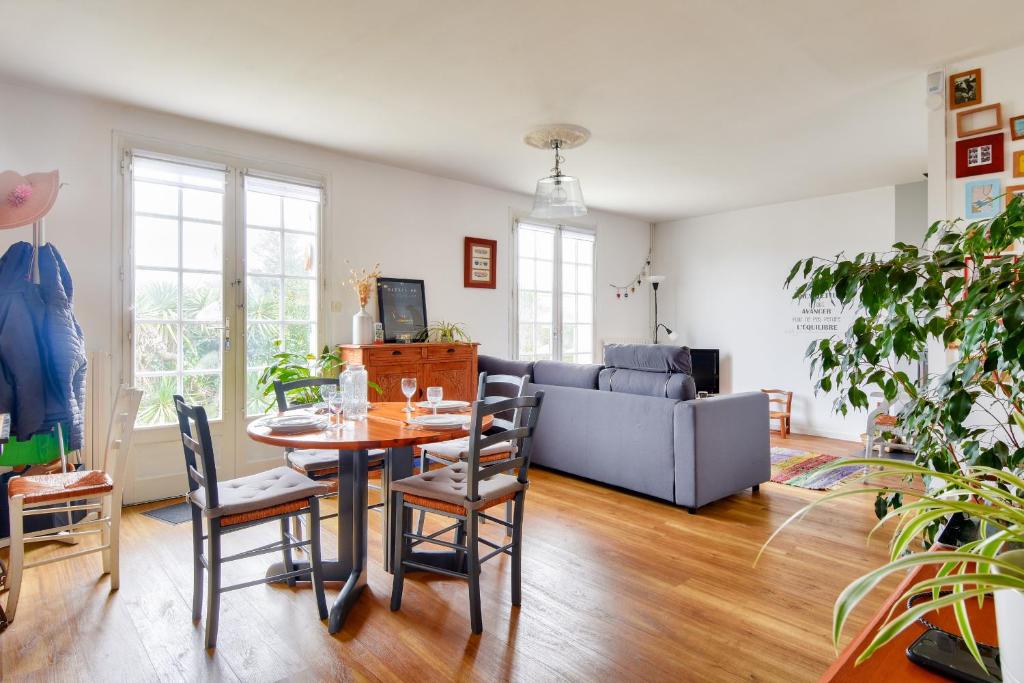 a living room with a table and chairs and a couch at Entre plage et marais salants, maison pour 6 in Les Bussolleries