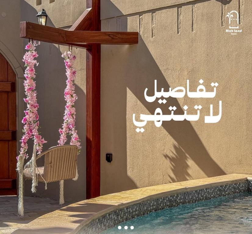 a sign on a wall next to a swimming pool at بيت أرض الثراء Rich Land House in Nizwa