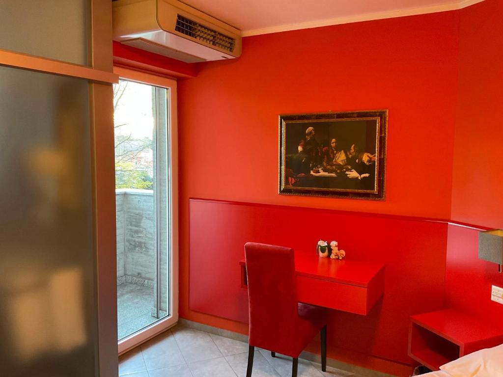 a red dining room with a red table and a window at Hotel Liberty Self Check-In in Bellinzona
