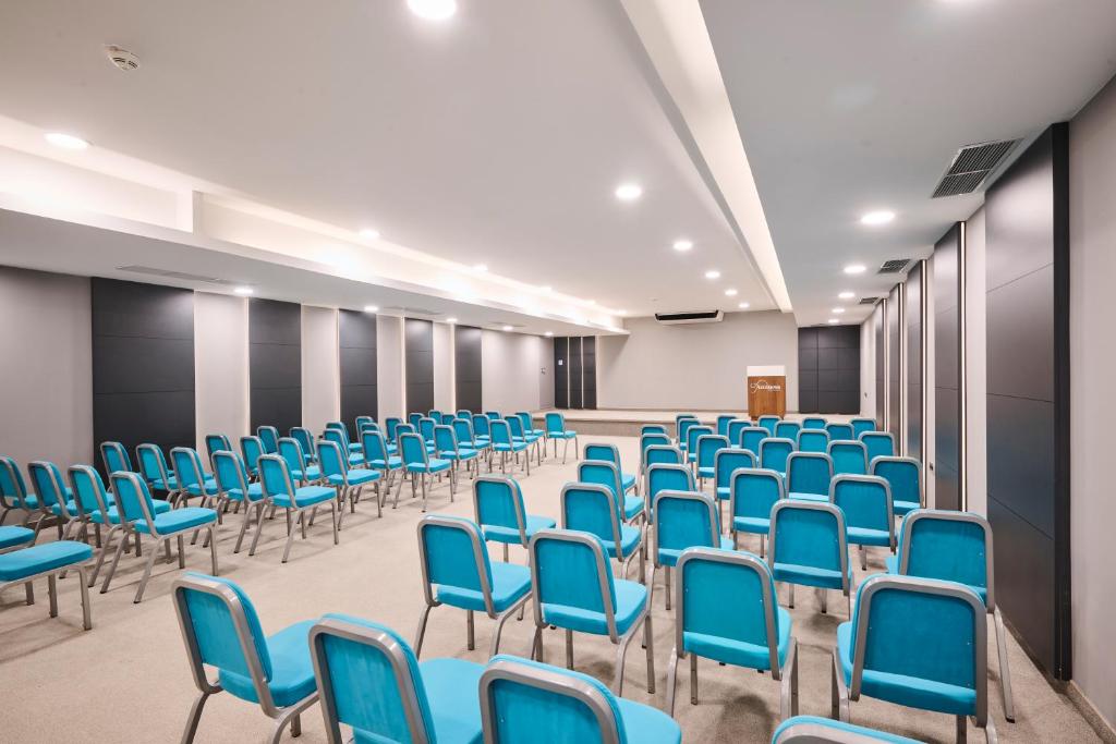 an empty conference room with blue chairs and desks at Aminess Vival Maestral Hotel in Novigrad Istria