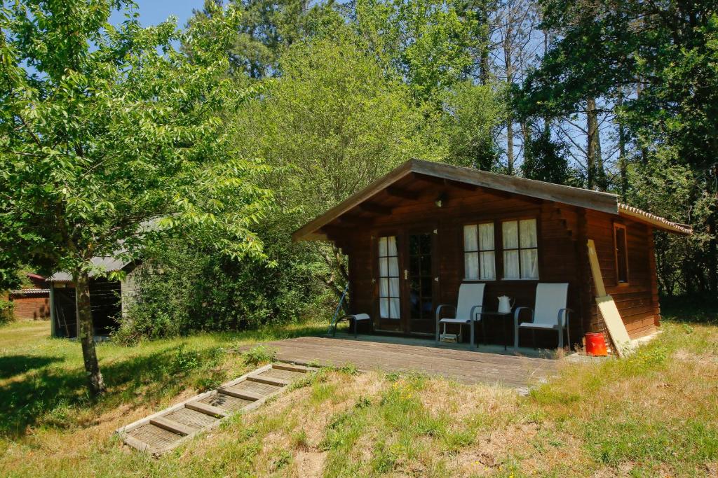 eine kleine Hütte im Wald mit einer Terrasse in der Unterkunft Domaine La faix, Gite le Verger in Saint-Plaisir