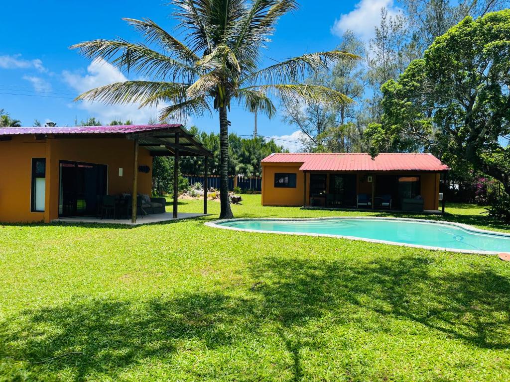 uma casa com uma palmeira e uma piscina em Twin House #2 em Ponta do Ouro