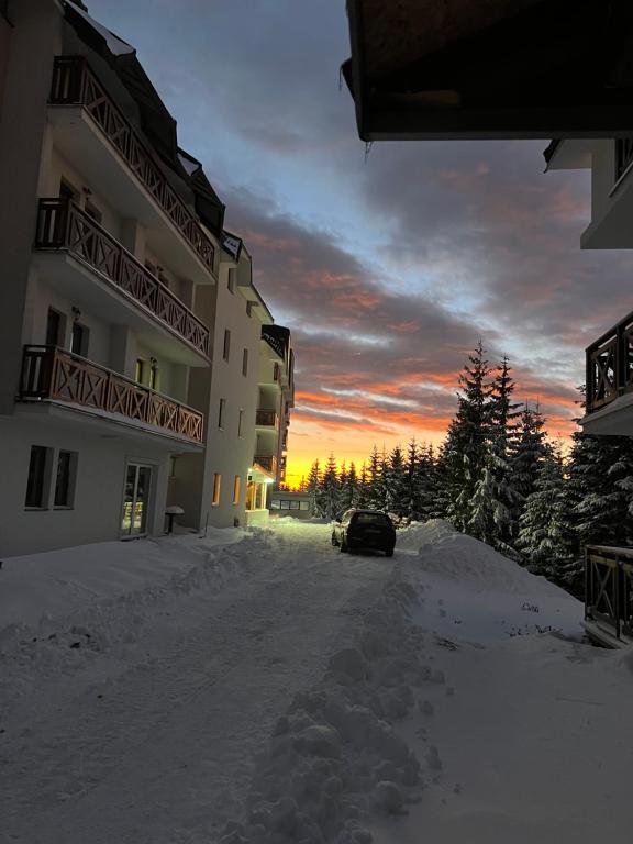 ein Auto, das im Schnee vor einem Gebäude parkt in der Unterkunft Studio M in Kopaonik