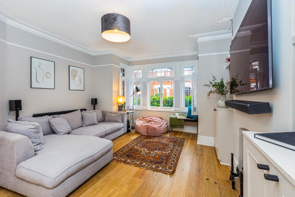 een woonkamer met een bank en een tafel bij Stunning 5BR Home, SW London, 5 min Twickenham St in Twickenham