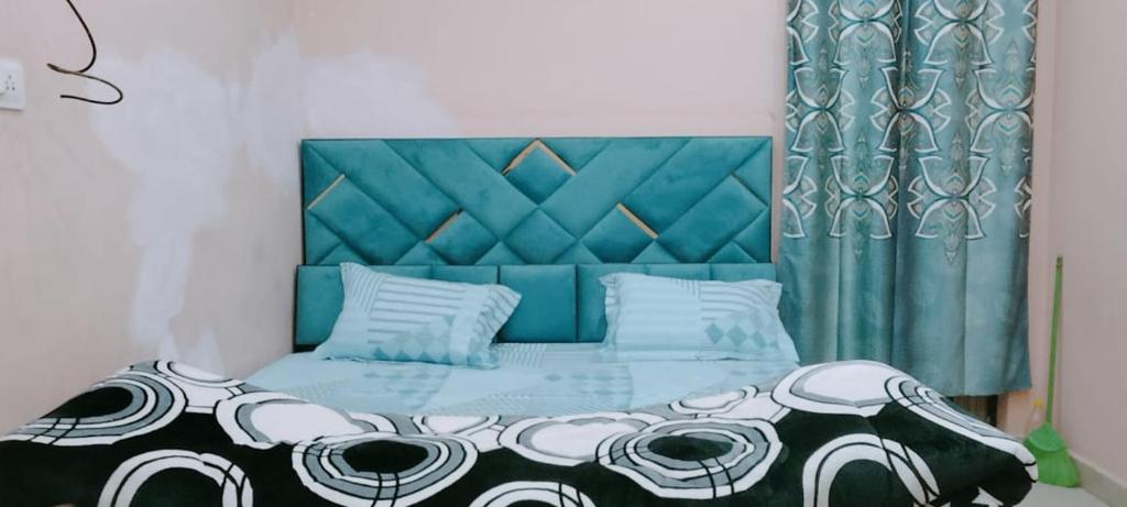 PRIYAMVADA FAMILY HOMESTAY في فريندافان: غرفة نوم مع سرير مع اللوح الأمامي الأزرق