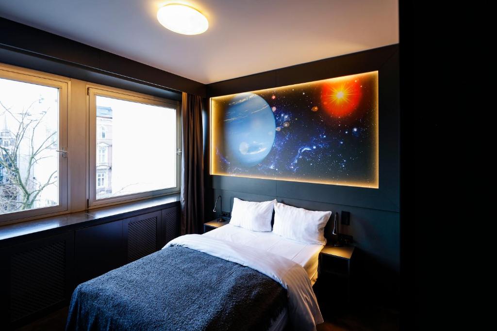 a bedroom with a bed and two windows with a planet at Sleephotels Cosmos in Hamburg