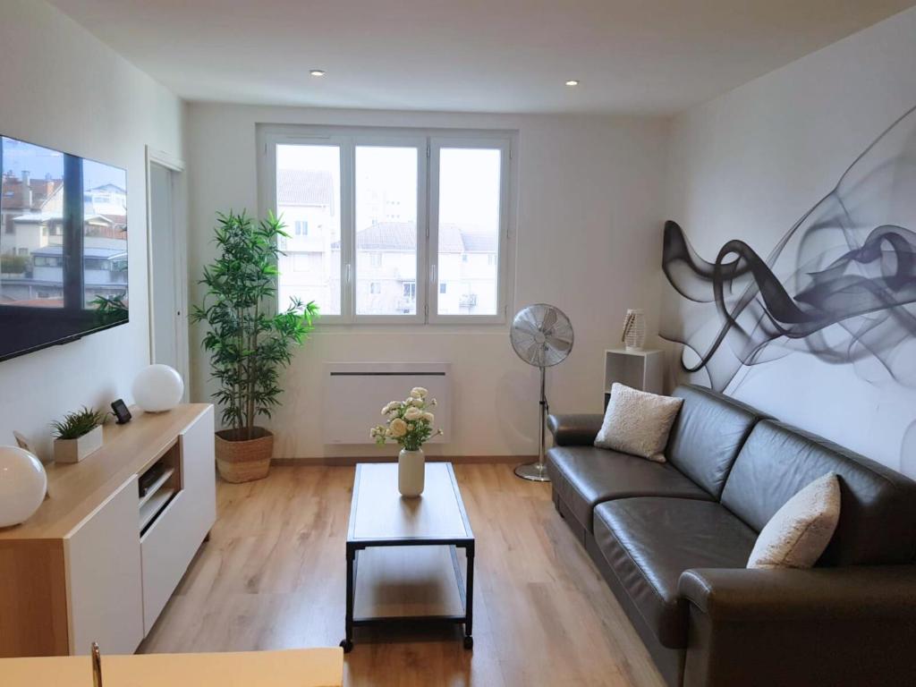 a living room with a couch and a table at Vue Montagne - Appt Cosy et calme - Netflix - Fibre in Grenoble