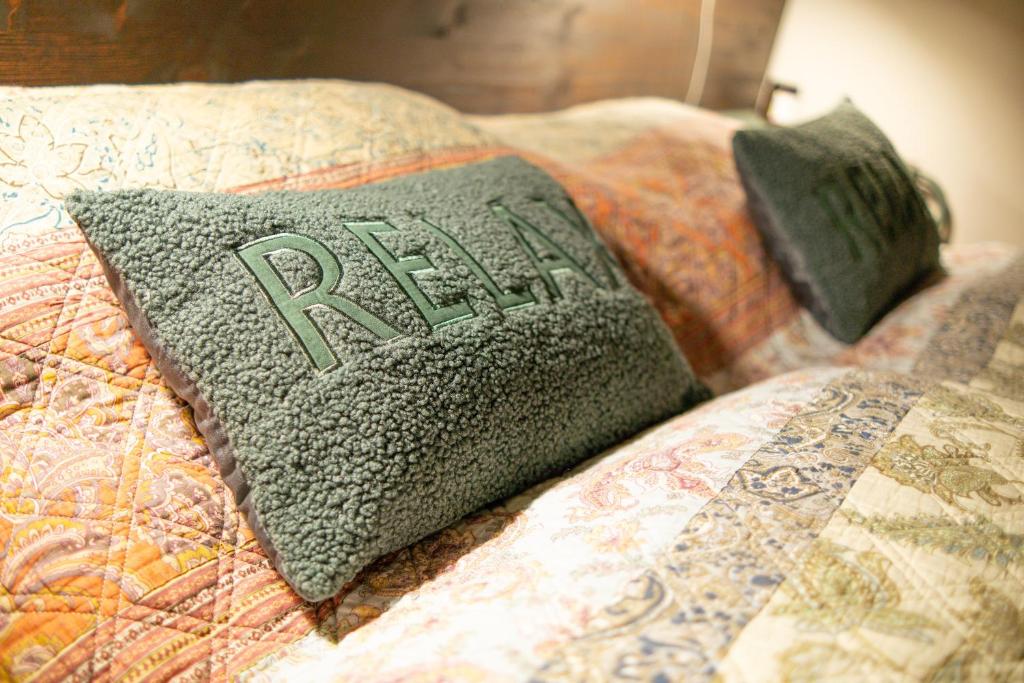 a pillow with the word relax on a bed at Big Schenkvalley in Erfurt