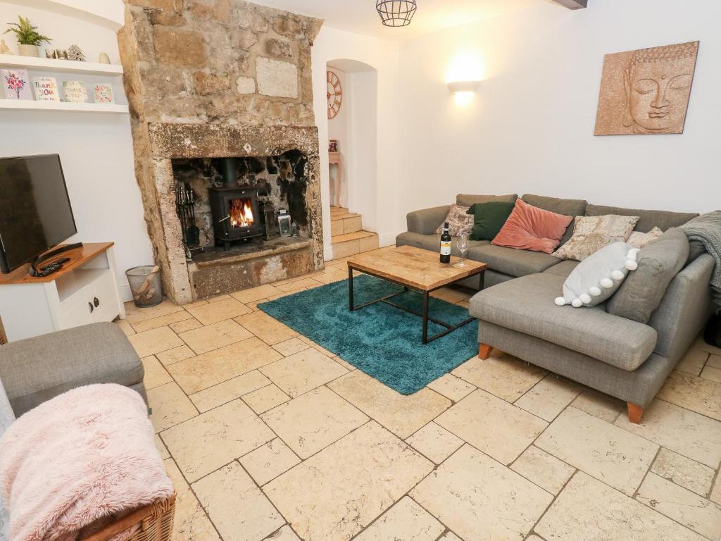 a living room with a couch and a fireplace at The Cottage in Yeadon