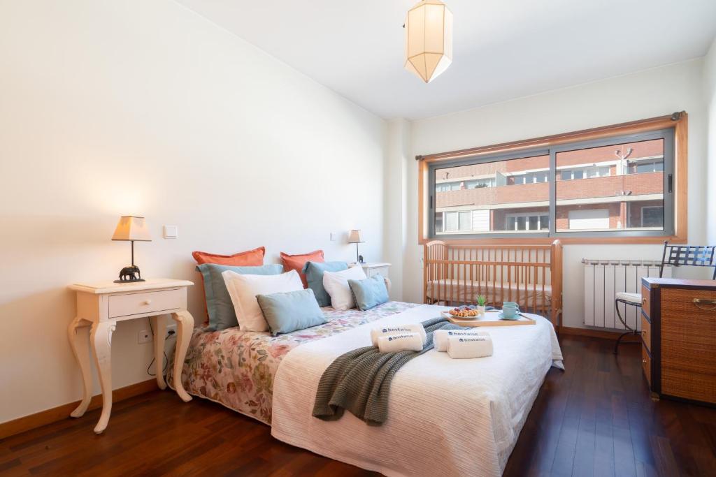ein Schlafzimmer mit einem großen Bett und einem Fenster in der Unterkunft Homely Large Flat - Balcony in Guimarães