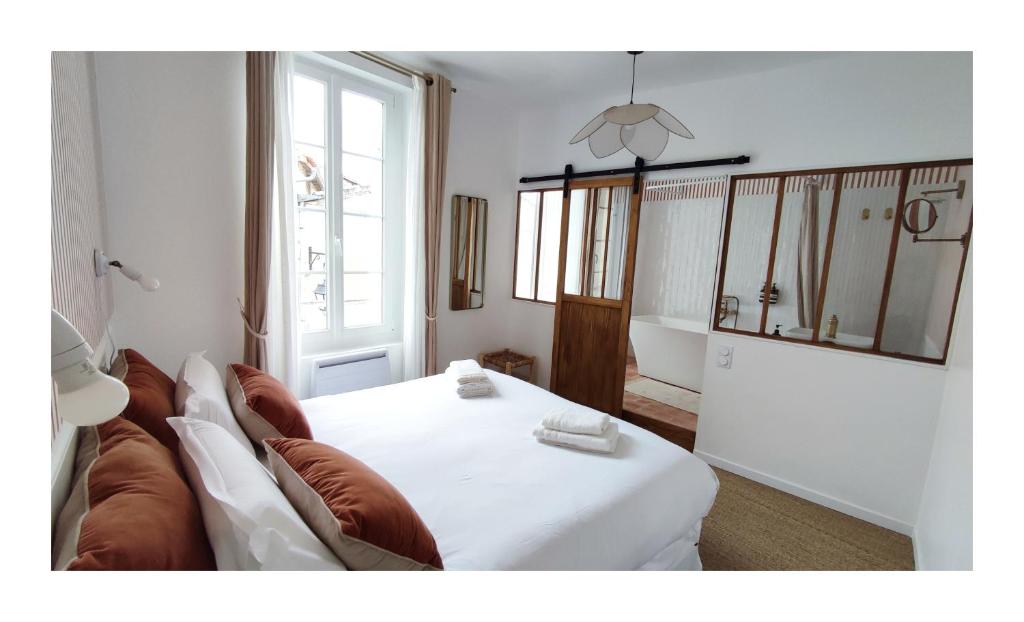 salon z białym łóżkiem i kanapą w obiekcie Maison Charmeilles - La suite Fronsac w mieście Fronsac