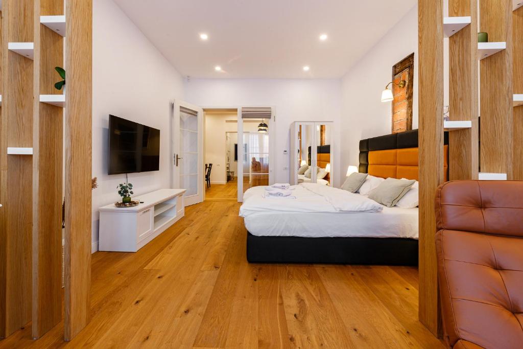 a bedroom with a large bed and a television at The Chic One, Unirii Square View in Timişoara