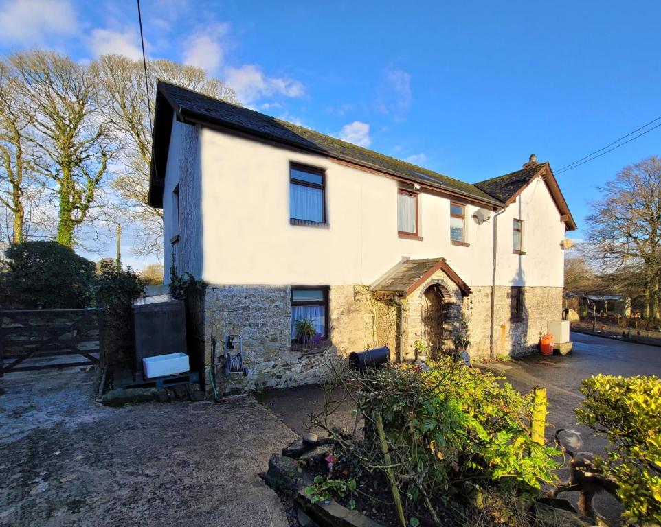 ein altes Steinhaus mit schwarzem Dach in der Unterkunft Charming pet friendly 2 bedroom cottage, close to Narberth & local beaches, friendly animals on our smallholding in Pembrokeshire