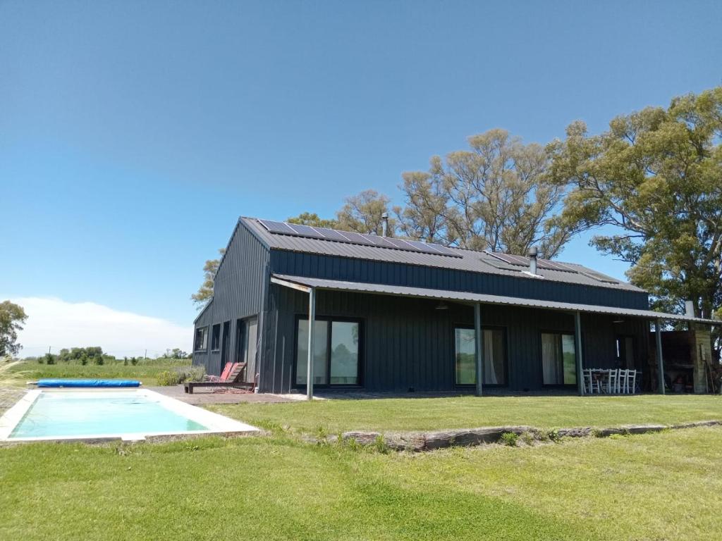 a house with a pool in front of it at Casa de Campo Galpon San Antonio de Areco in San Antonio de Areco