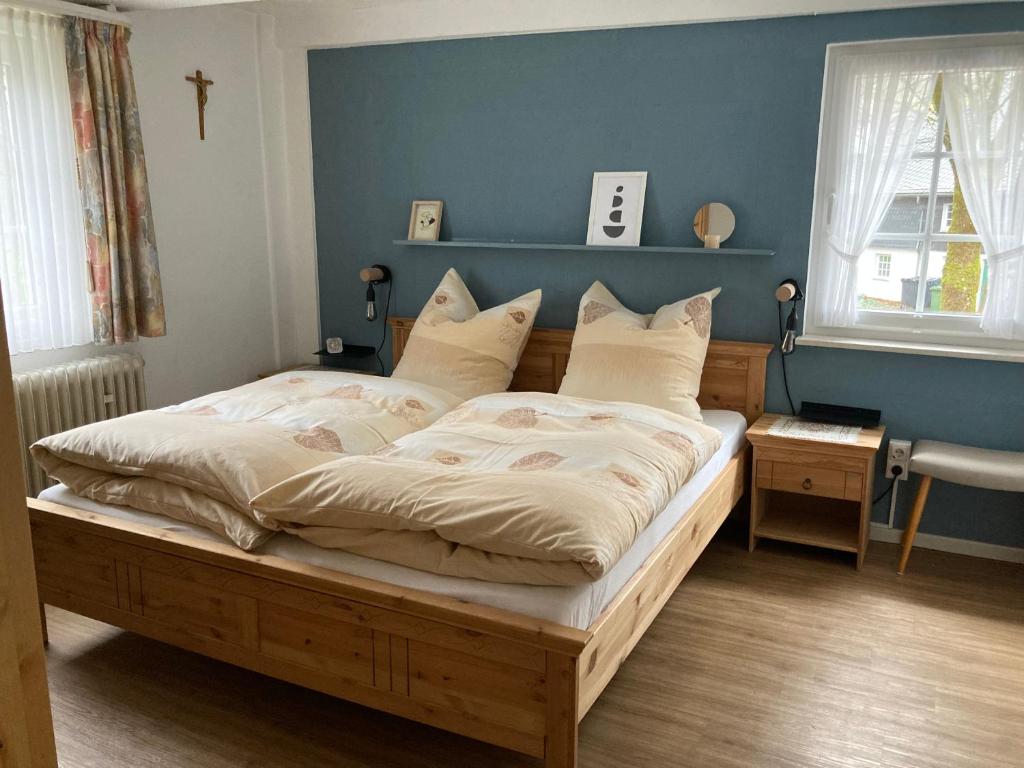 1 dormitorio con 1 cama grande y pared azul en Pension Alois Hennecke, en Schmallenberg