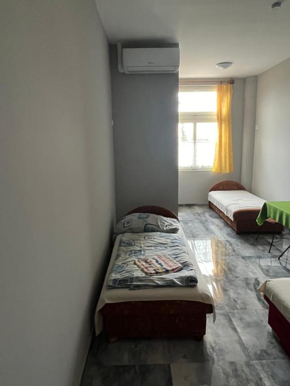 2 camas en una habitación pequeña con ventana en Lilla motel en Hegyeshalom