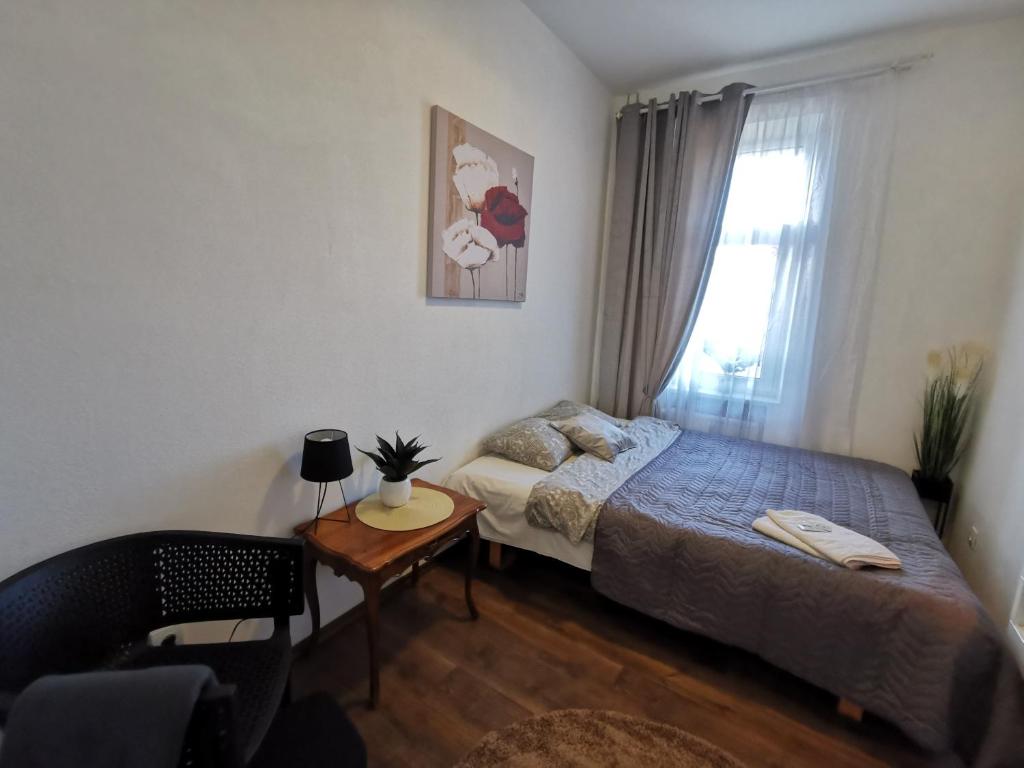 Schlafzimmer mit einem Bett, einem Tisch und einem Fenster in der Unterkunft 8 Small studio apartment in Klaipėda
