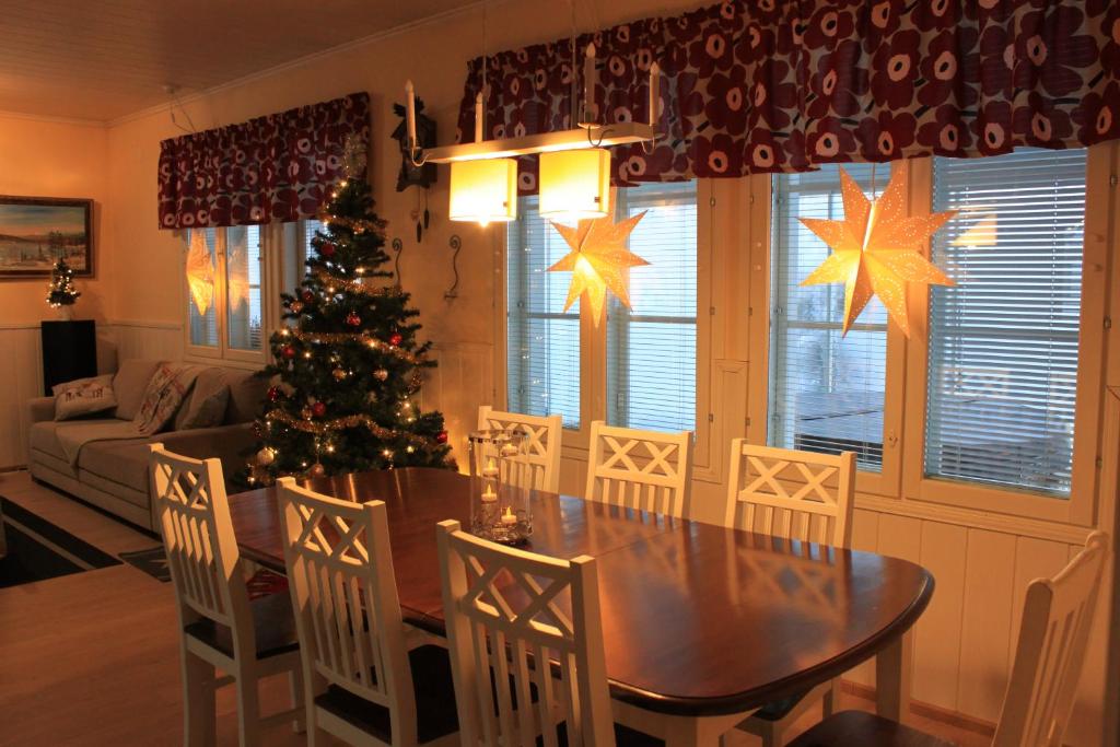 a dining room with a table and a christmas tree at Villa Koivikko in Rovaniemi