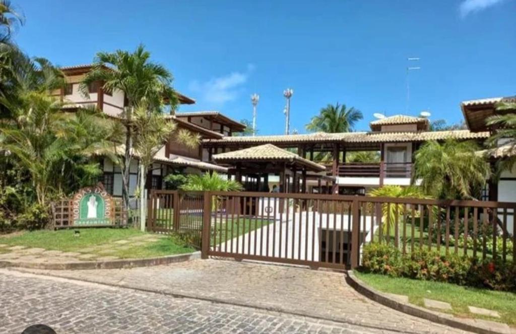 a house with a gate in front of it at Apartamento duplex em Praia do Forte - 2 suítes in Praia do Forte