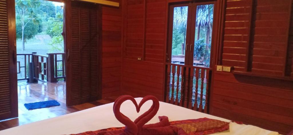Koh Jum Freeda Resort في كو جوم: وجود قلب احمر على طاولة في غرفة بها نوافذ