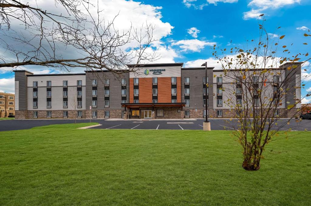 a building with a green lawn in front of it at WoodSpring Suites Dearborn Detroit in Dearborn