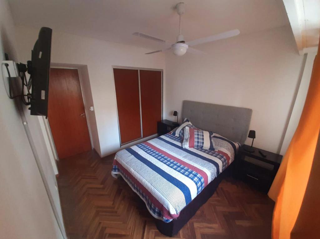 een slaapkamer met een bed en een plafondventilator bij Amplio departamento a dos cuadras del río Paraná, a tres de la peatonal y a seis del Monumento a la Bandera. Ambiente familiar. in Rosario