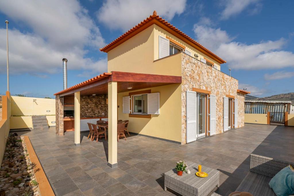 a villa with a patio and a house at Family vacation on Golden Island La Maison Dorée in Porto Santo