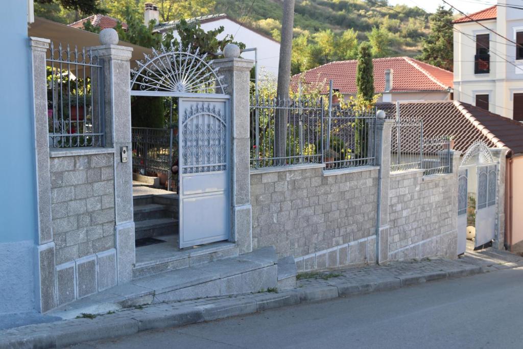 a brick fence with a white door in a house at Vila Tradicionale Violeta Korce in Korçë