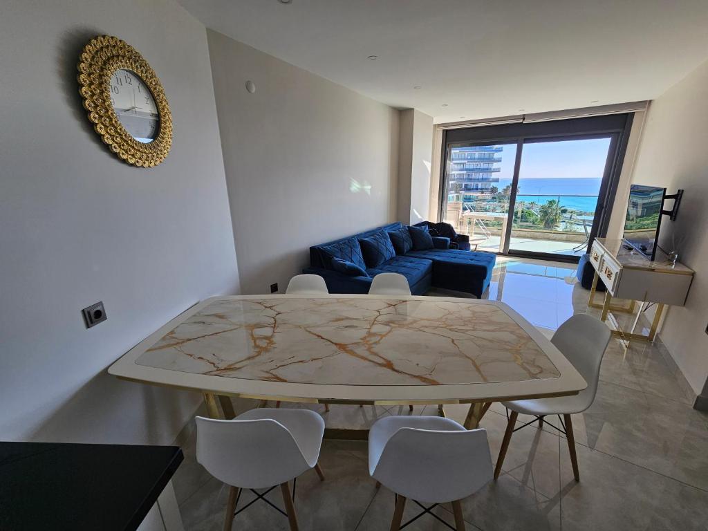 ein Wohnzimmer mit einem Tisch und einem blauen Sofa in der Unterkunft Konak Tower Seaside mahmutlar in Alanya