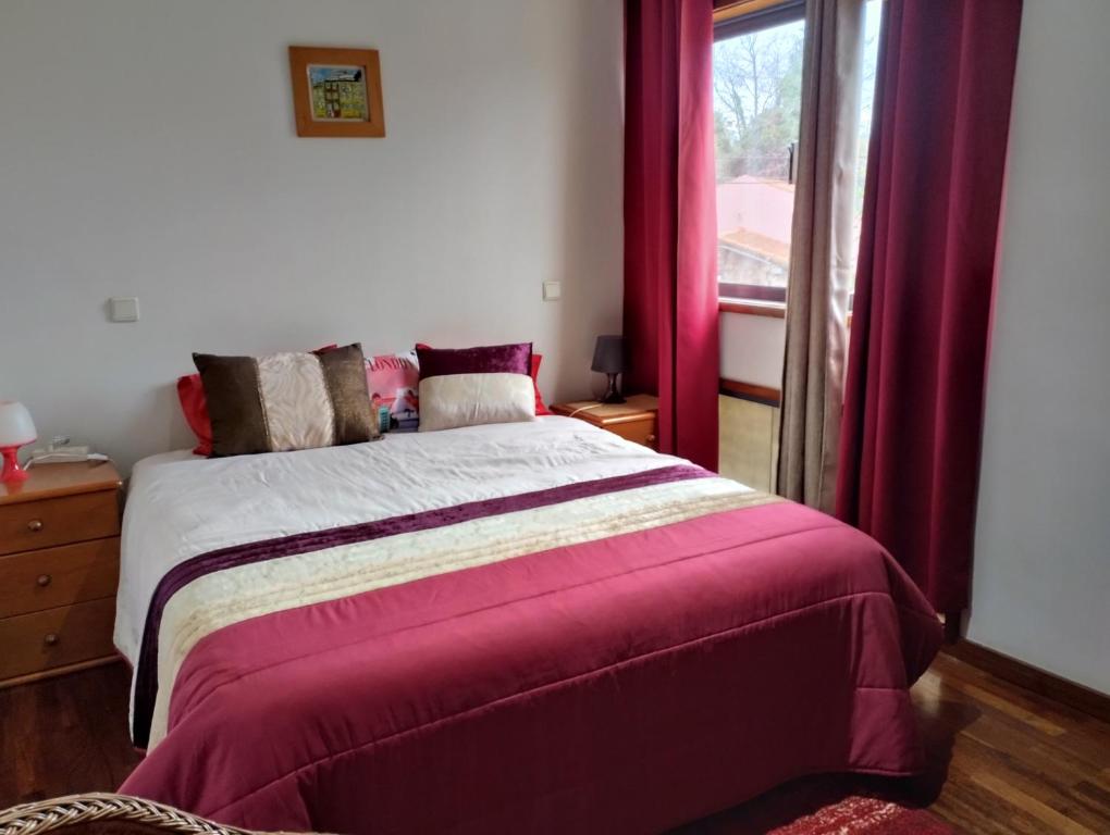 エスピーニョにあるSweets Suitesのベッドルーム1室(赤いカーテンと窓付きのベッド1台付)