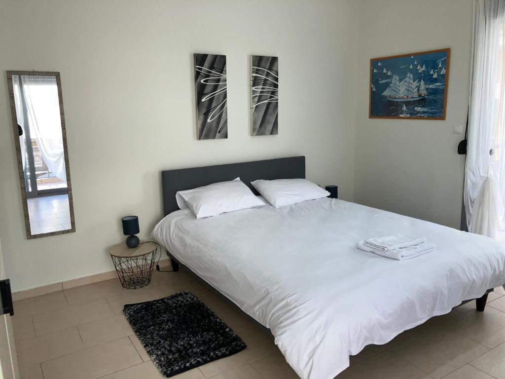 - une chambre avec un grand lit blanc et 2 oreillers dans l'établissement Lamia central luxury apartment, à Lamía