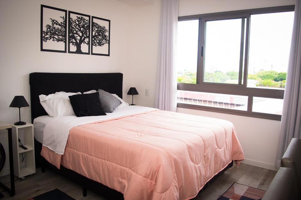 a bedroom with a large bed and a window at Apartamento ao Lado do metrô Carrão in Sao Paulo