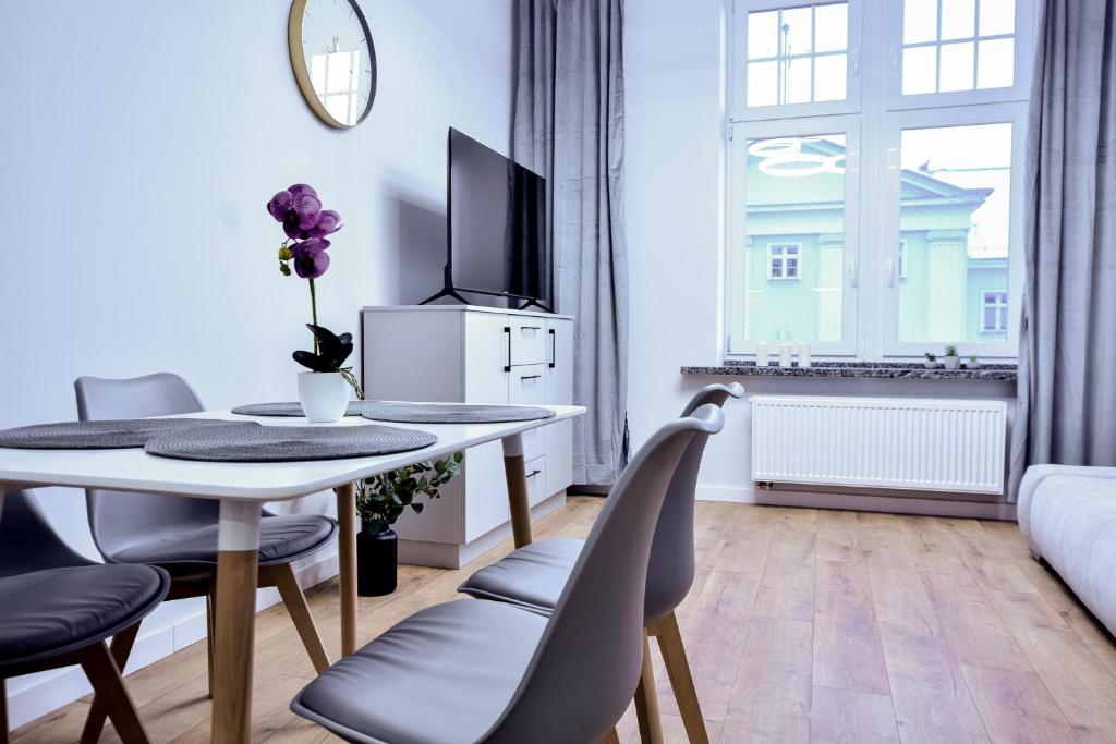 a living room with a table and chairs and a window at VacationClub - Old Town Apartament 11 in Kłodzko