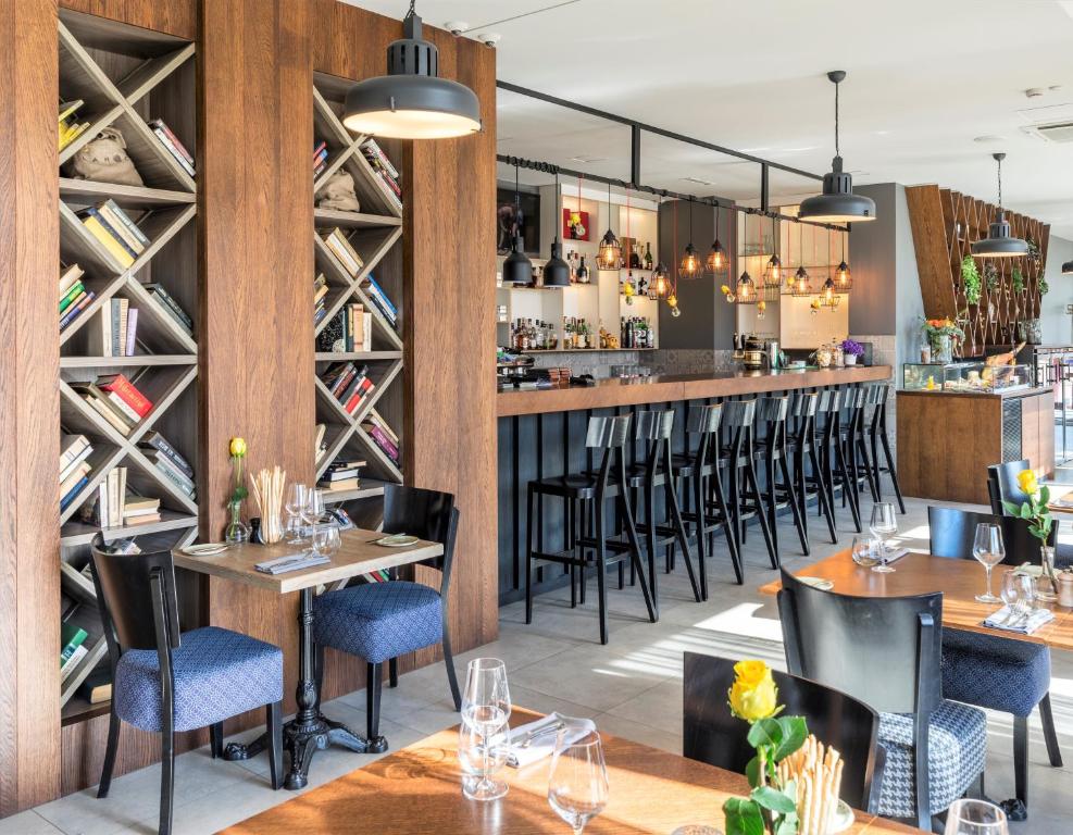 um restaurante com mesas e cadeiras e um bar em Wellton Riga Hotel & SPA em Riga