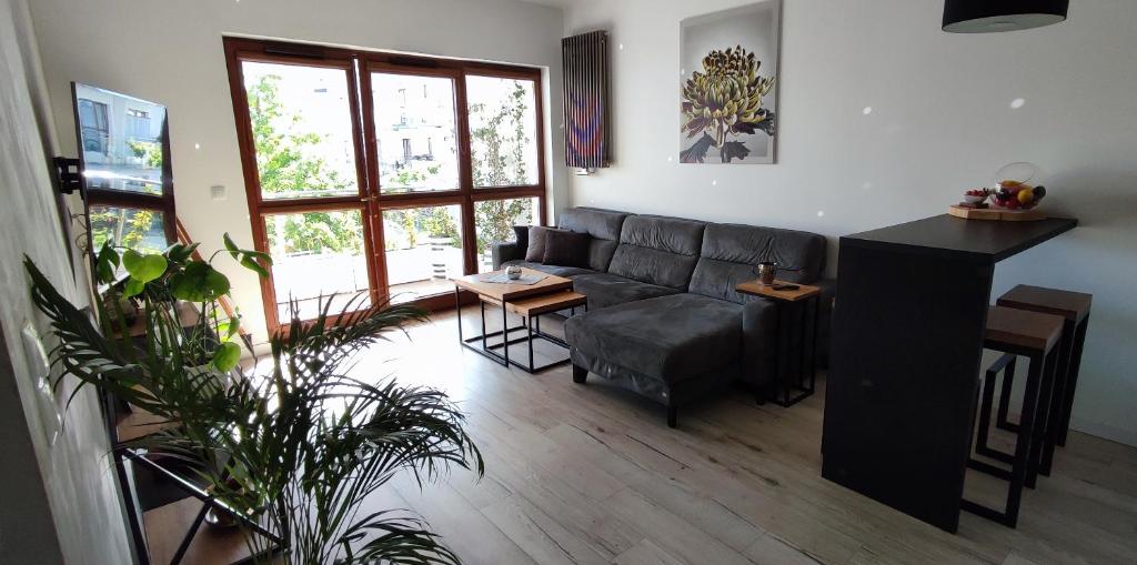 ein Wohnzimmer mit einem Sofa und einem Tisch in der Unterkunft Apartament Modern Wilanow in Warschau