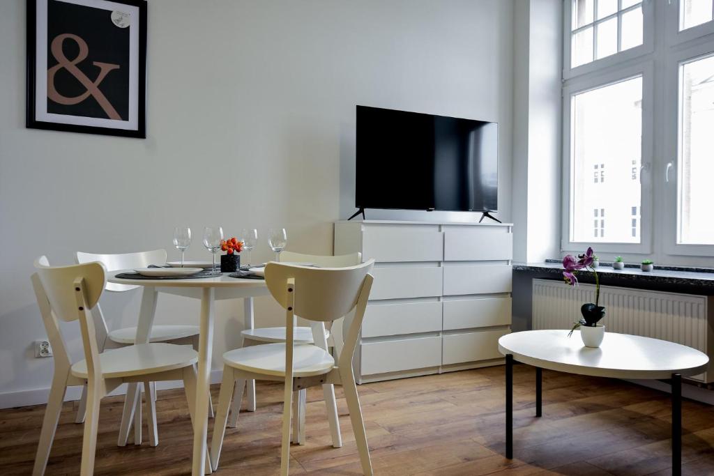 a dining room with a table and chairs and a tv at VacationClub - Old Town Apartament 1 in Kłodzko